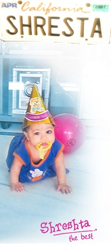 Shreshta in her 9th month moving around the home with a joker cap on head and teether in her mouth.